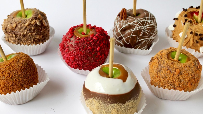 An assortment of candy apples with various toppings