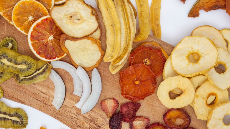 Various types of dried fruit on a wooden board