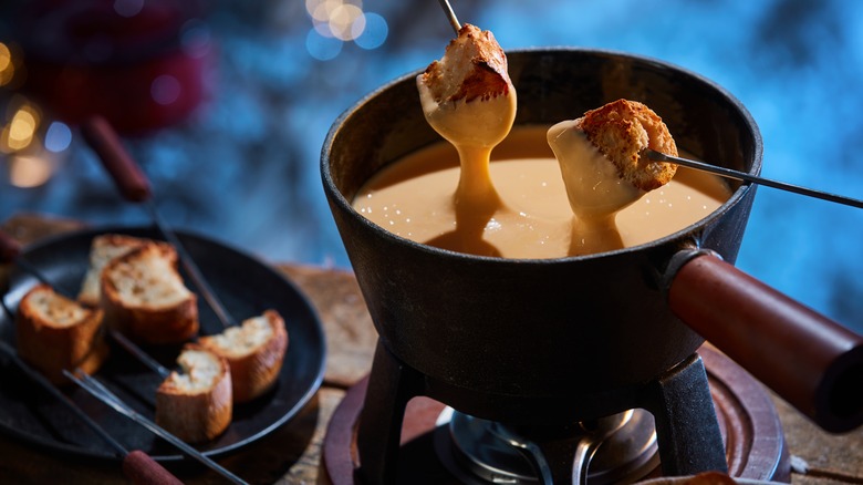 Bread dipped in fondue cheese