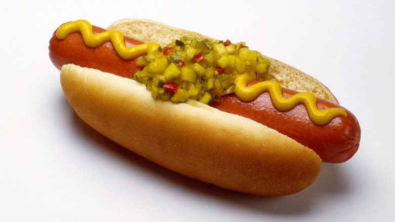 A hot dog with mustard and relish in a bun
