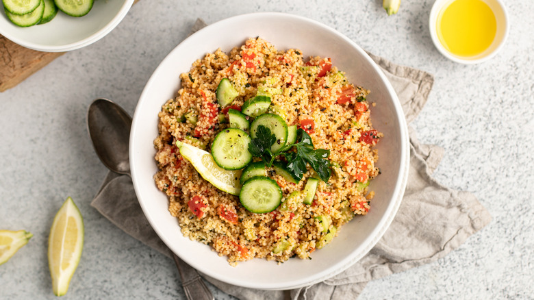 A bowl of couscous with cucumber on top