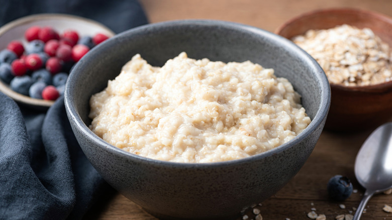 Oatmeal in gray bowl next to fruit