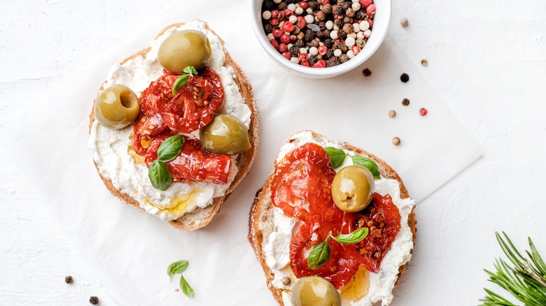 Bagel with ricotta and tomato on paper