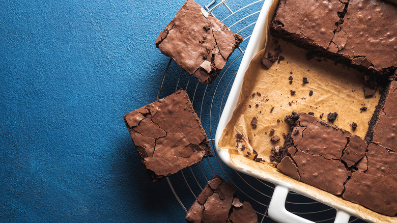 Brownie squares sitting next to baking pan