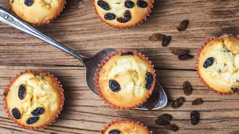 Bran muffins with raisins on spoon with wooden table