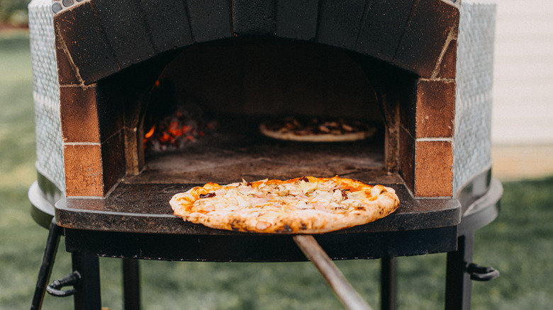 pizza going into pizza oven