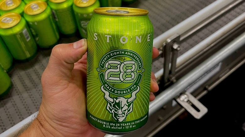 A hand holding a Stone Brewing beer can