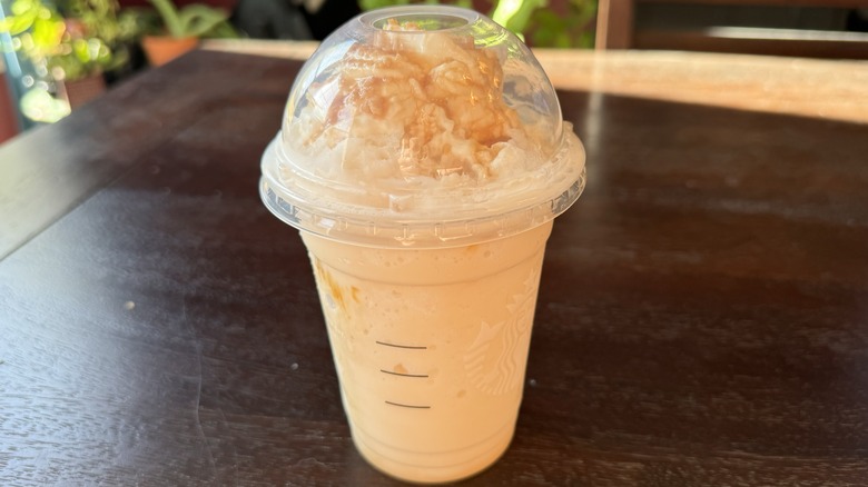 A takeout plastic drink of Starbucks Caramel Ribbon Crunch Crème Frappuccino Blended Beverage