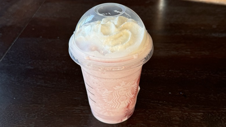 A takeout plastic drink of Starbucks Strawberry Crème Frappuccino Blended Beverage