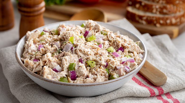 A bowl of tuna salad with red onions and celery