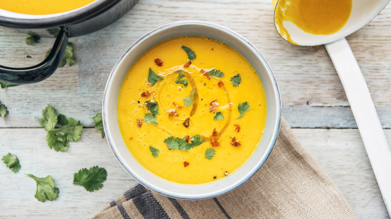 A bowl of butternut squash soup garnished with cilantro