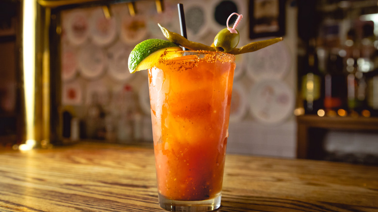 A Bloody Mary garnished with a lime, olive, and pickled green bean