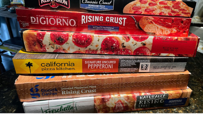 A stack of frozen pizzas in boxes