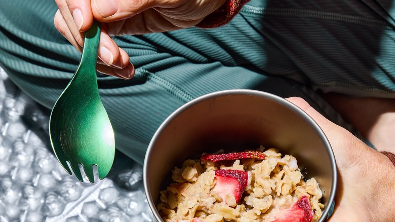 hand holding cup of oatmeal