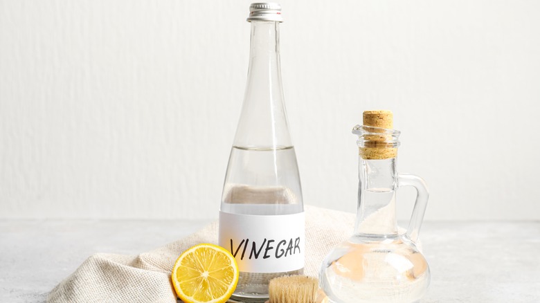 Vinegar in bottle and lemon