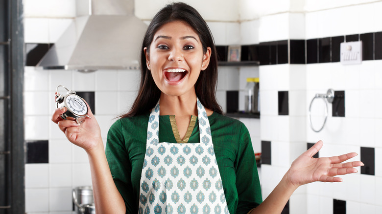 Woman holding timer in kitchen