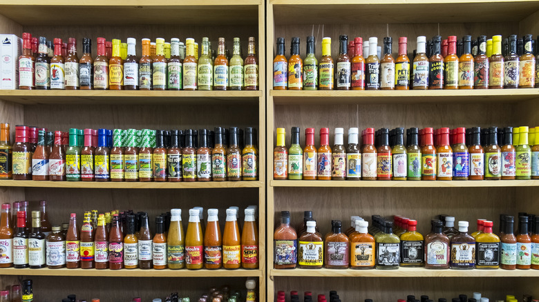 Shelves of hot sauce are on display at a market