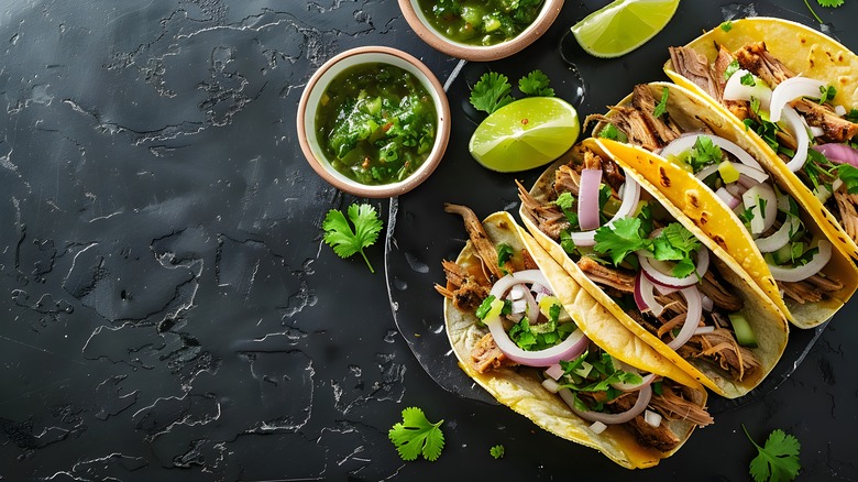 Four tacos de carnitas with salsa verde