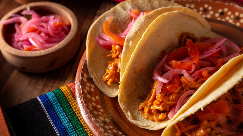 Tacos de cochinita pibil with pickled red onions