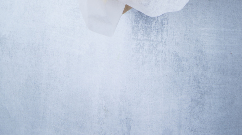 A pie shell is filled with clay weights in parchment paper for blind-baking.