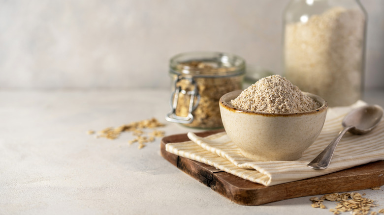 Oat flour and whole oats are arranged on a table.