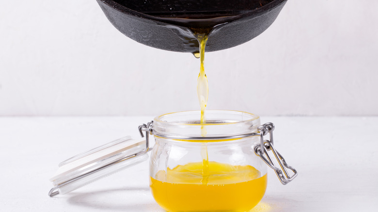 pouring clarified butter into jar