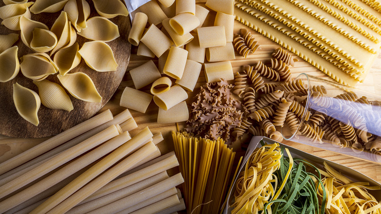 Several types of dried pasta on a wooden tabletop