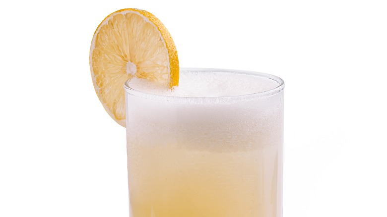 Froth lemonade is garnished with a lemon wheel.
