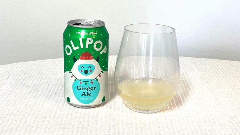 a can of Olipop Ginger Ale sitting beside a glass containing a sample