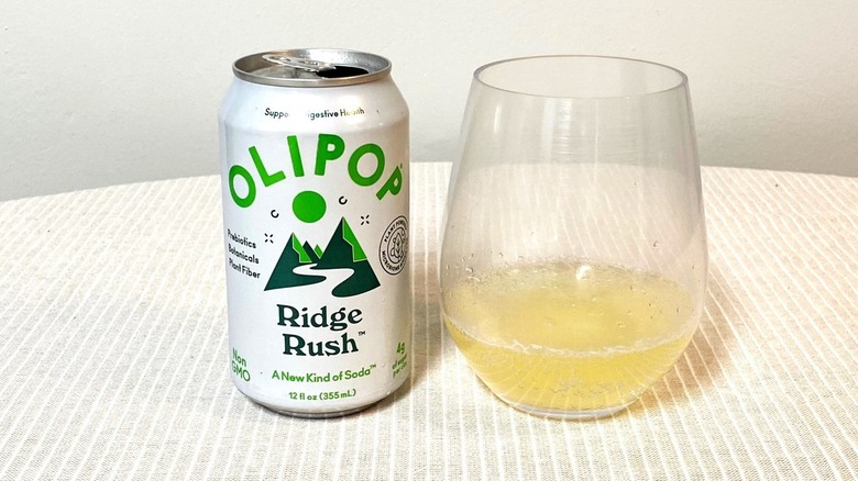 a sample of Olipop's Ridge Rush soda sits in a glass beside an open can