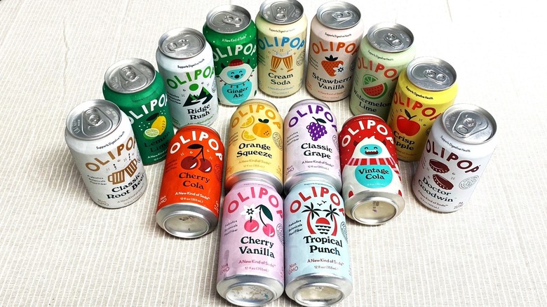15 cans of Olipop flavors arranged decoratively on a table