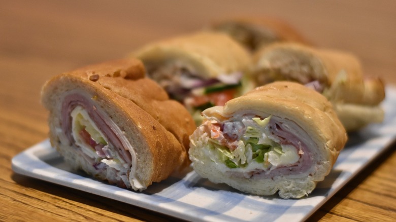 Samples of Subway sandwiches on a blue and white tray on a wooden table