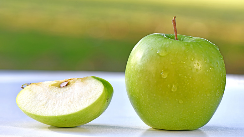 A green apple with a slice cut out