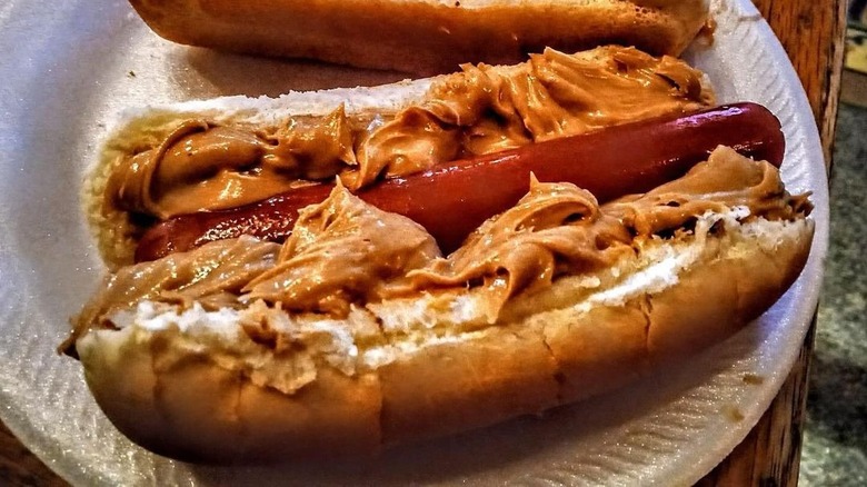 hot dog with bun smeared with peanut butter