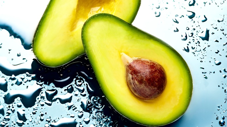 Halved avocado with water background