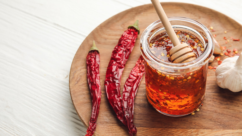 Jar of honey with fresh and dried chilis