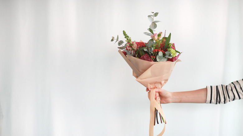 hand holding bouquet of flowers