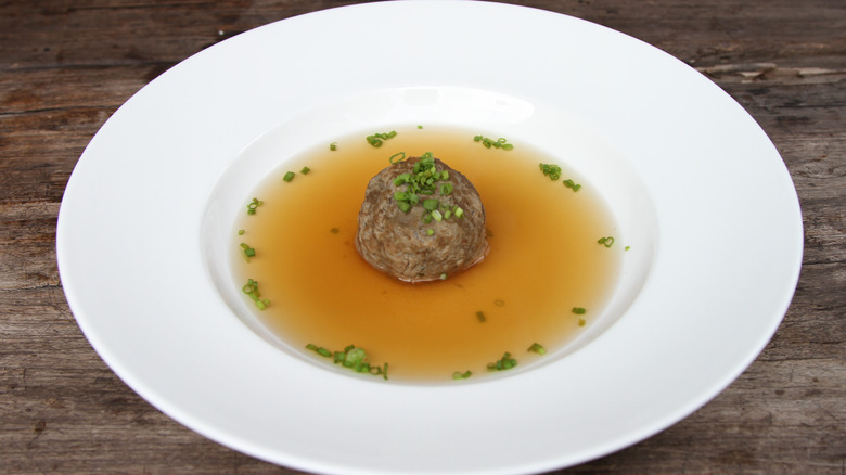 Bowl of beef consommé with meatball in the center