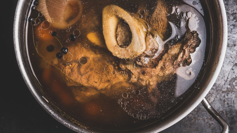 Beef stock cooking in a silver pot