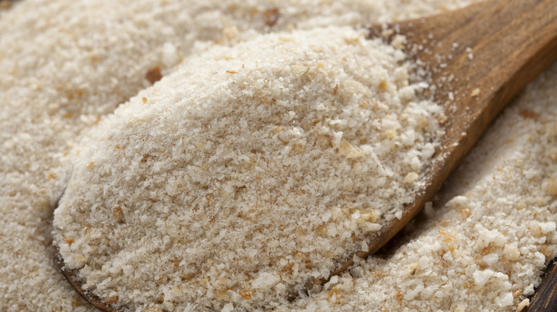 Wooden spoon in bowl of breadcrumbs