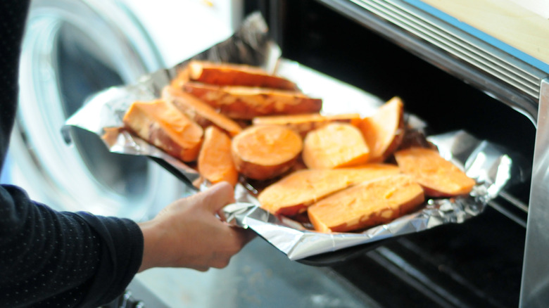 Putting sweet potatoes in the oven