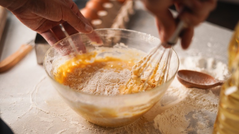 Whisking flour and eggs in bowl