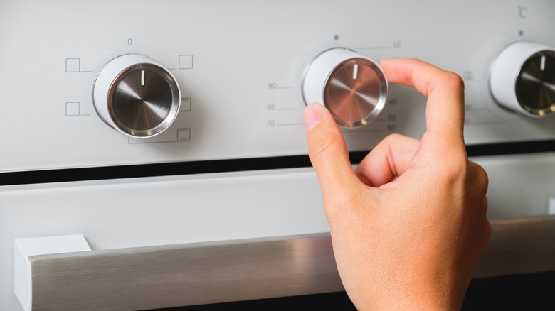 hand adjusting oven dial