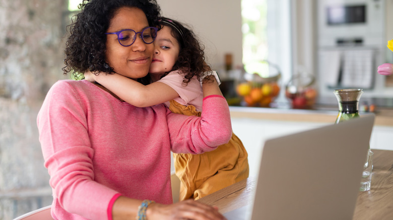 Woman with kid watching laptop