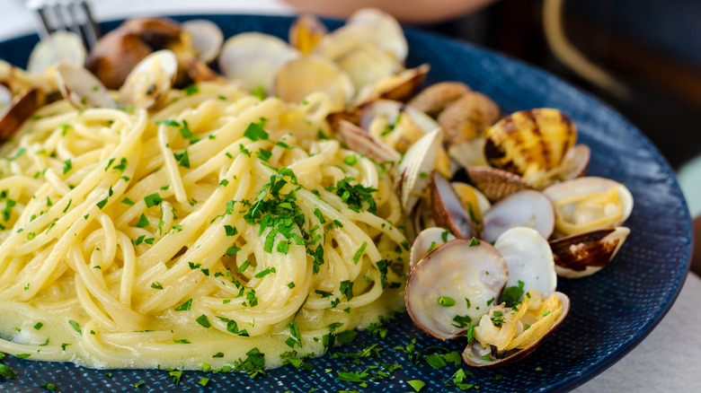 Spaghetti and clams Posillipo on a blue plate