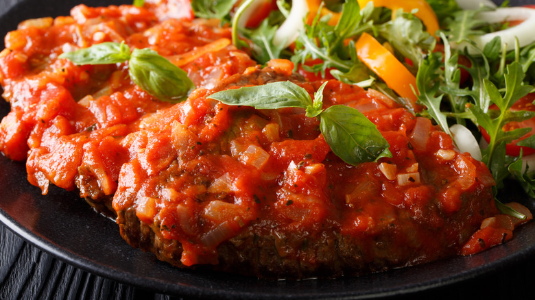 Steak with pizzaiola sauce and a salad