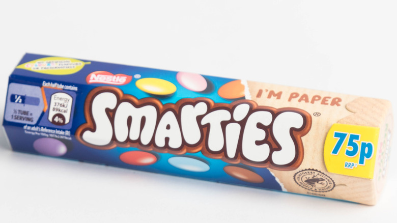 A package of chocolate Smarties on white background