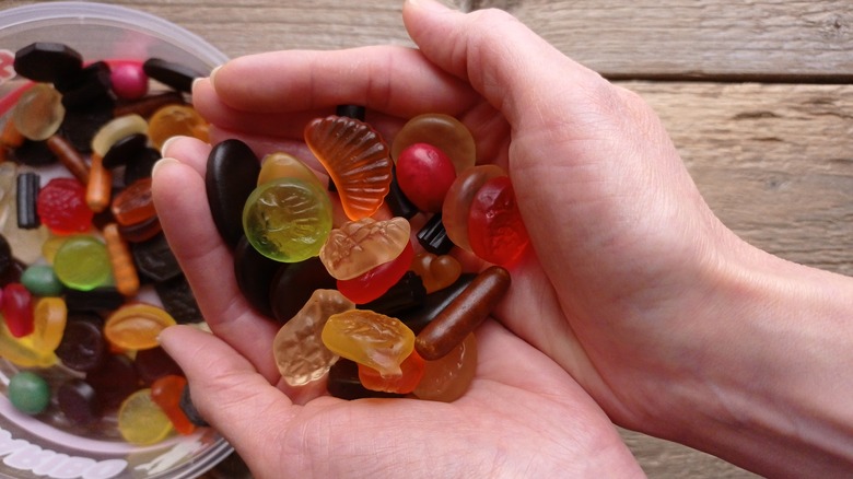 Hands holding Wine Gums over container