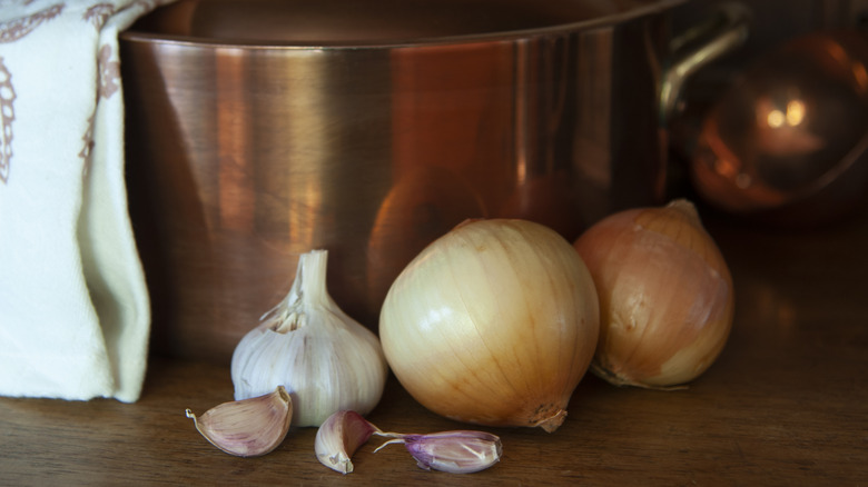copper cooking pot with onion in foreground