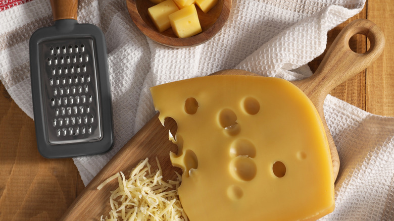 small cheese grater next to swiss cheese